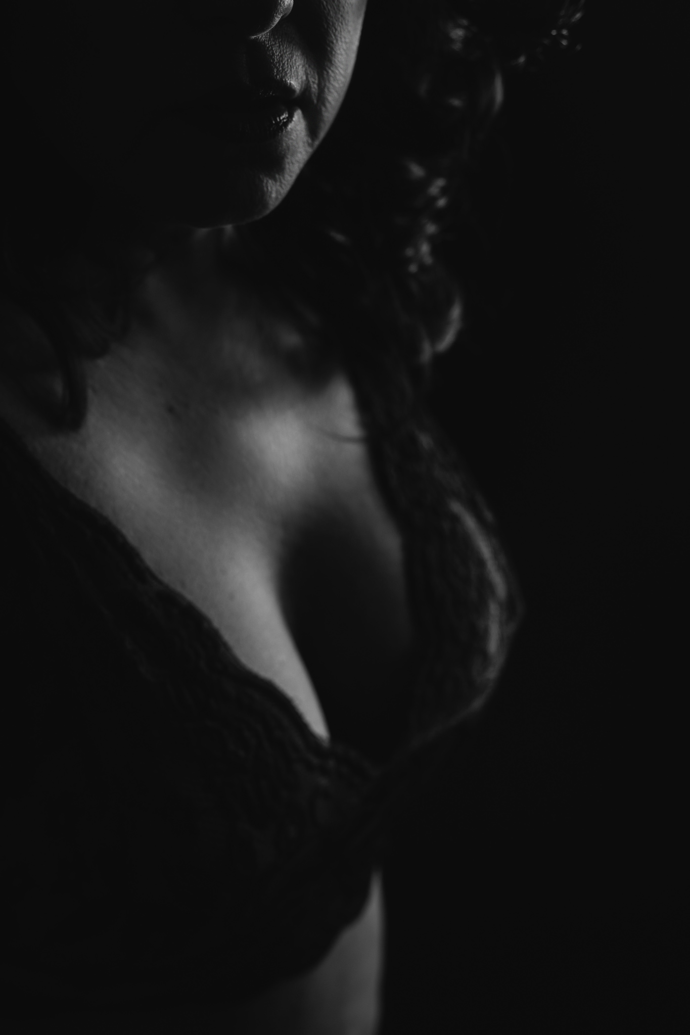 Details of a woman standing in a dark studio in a lace bra after some pole fitness austin