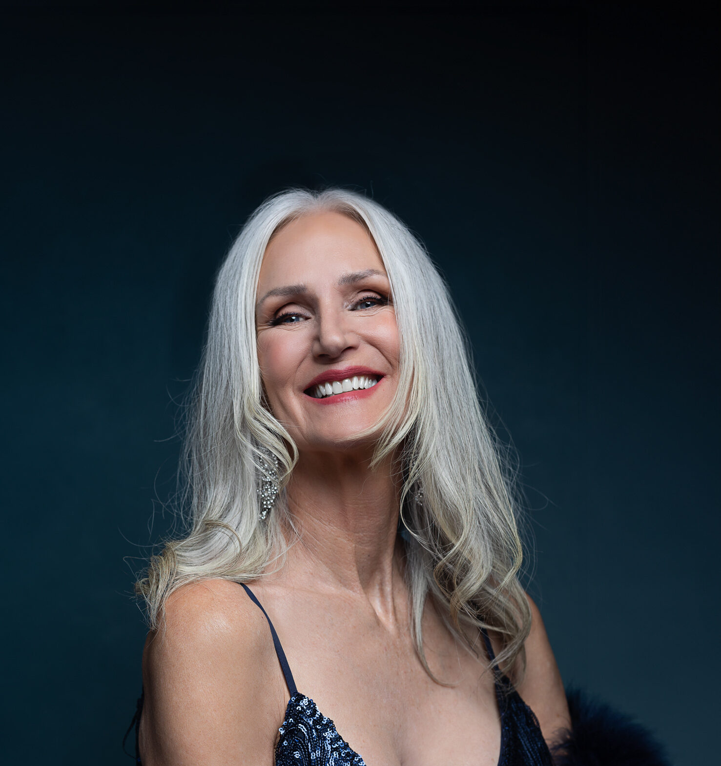 A happy woman in blue lingerie smiles while sitting in a studio before visiting romantic restaurants in austin