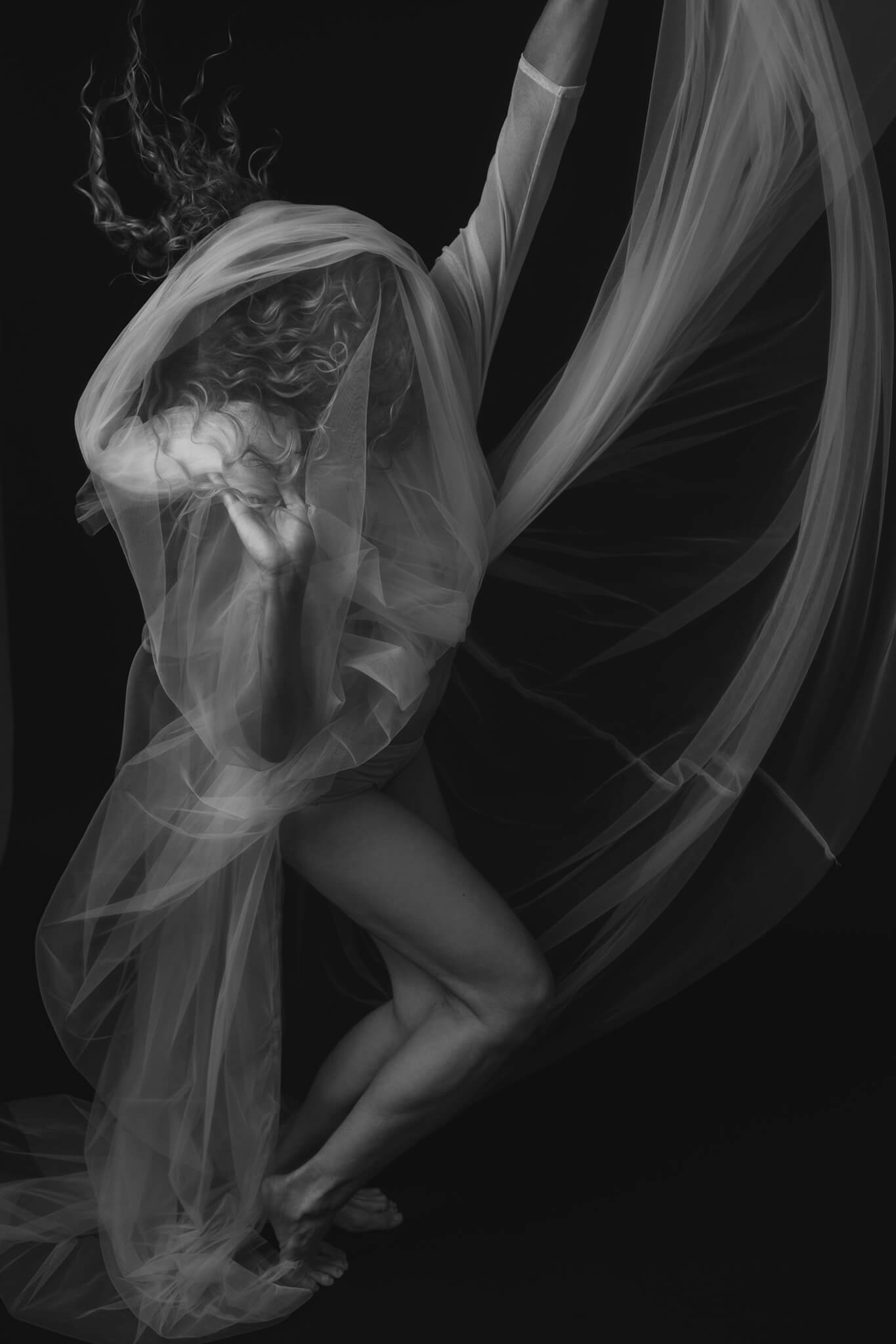 Dancer is throwing her tulle dress in a photo in black and white in an artistic way