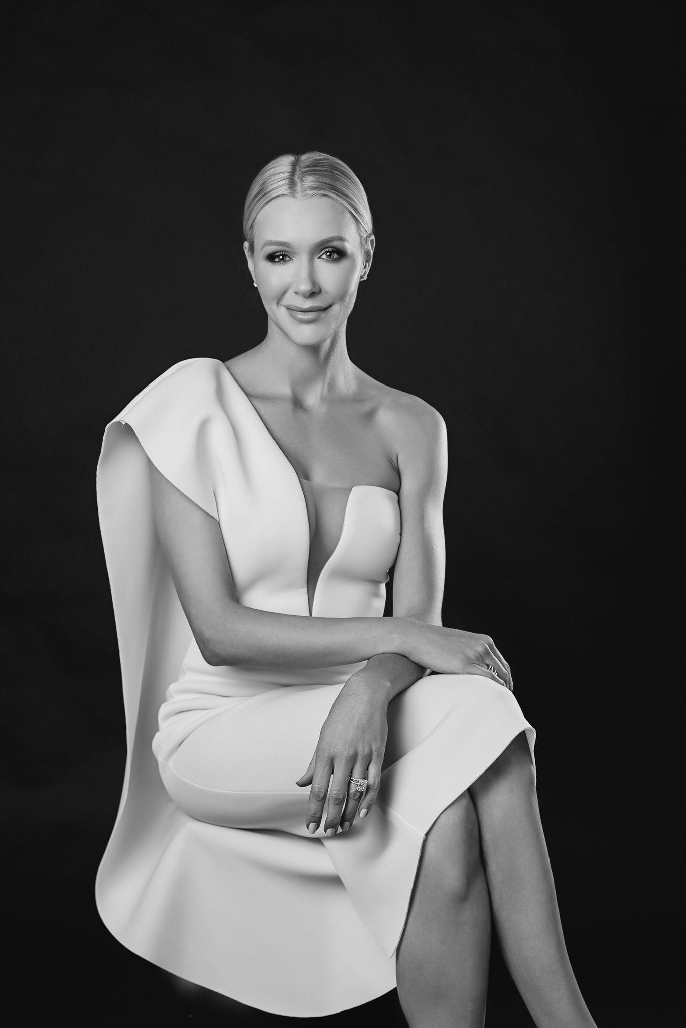 blonde woman is posing in an elegant way in a black and white portrait showing the magic of professional photography