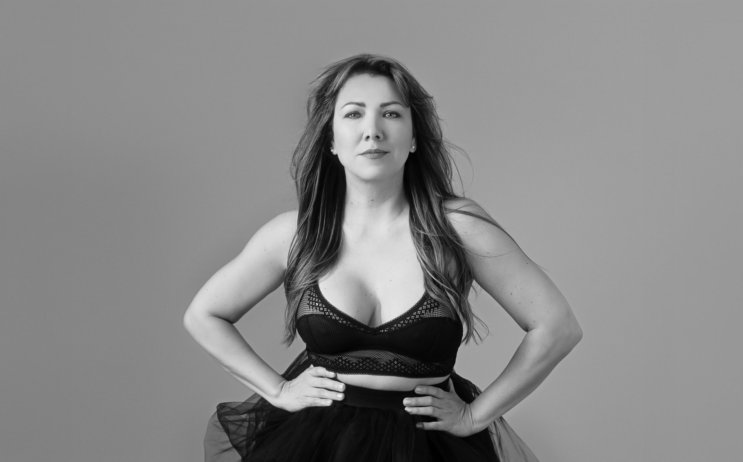 black and white horizontal image of a latino woman doing what is called the power pose for glamour photoshoots