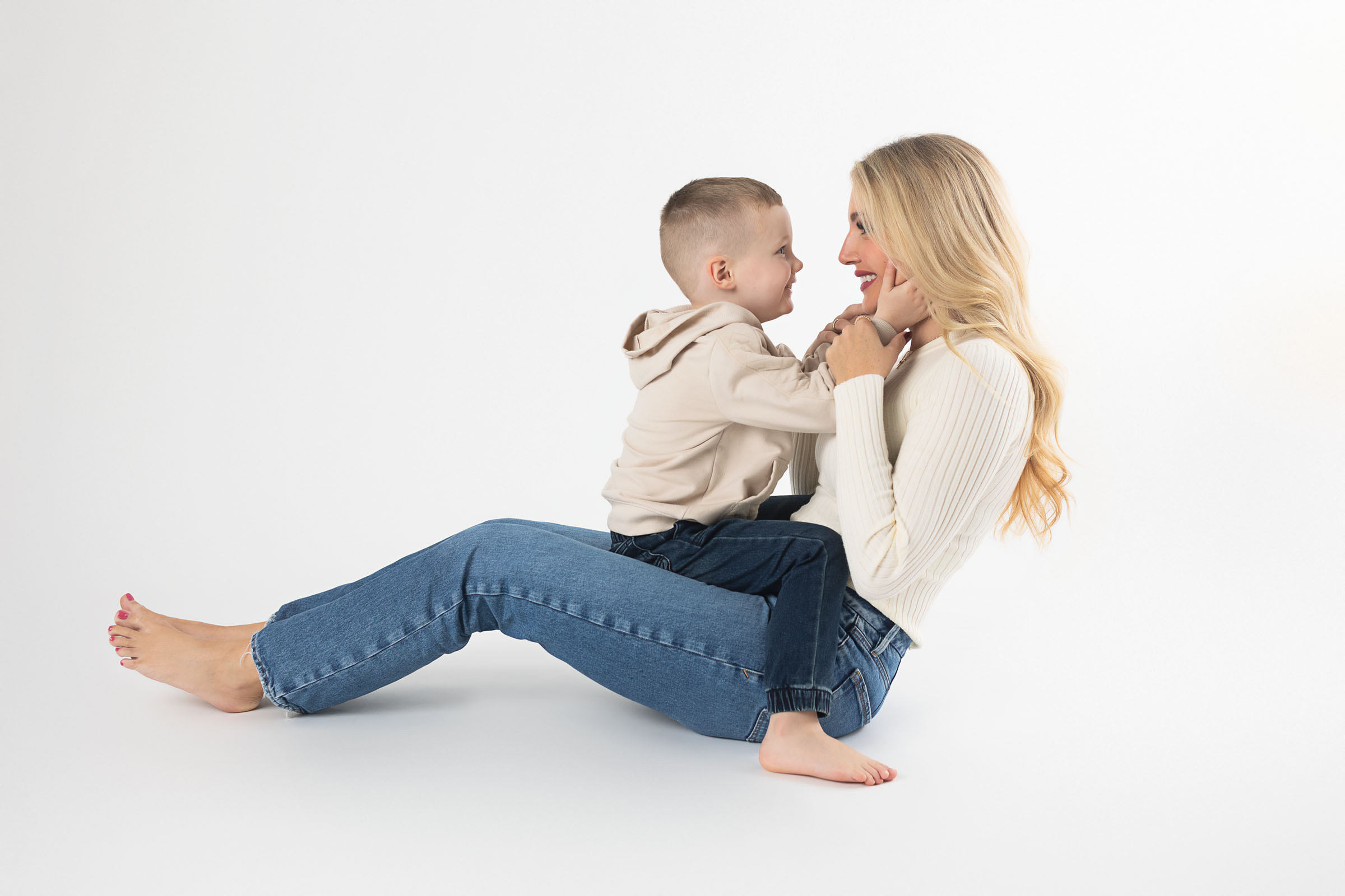 Mom and son image taken at Austin studio photographer over white backdrop and wearing earth colors