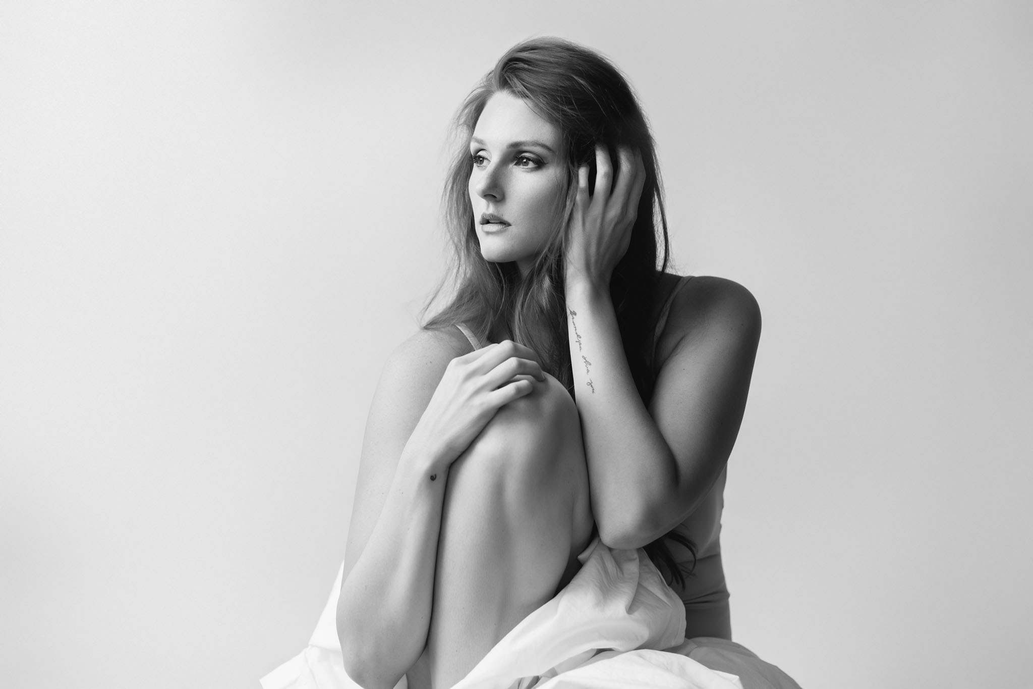 black and white boudoir image of a your brunette woman in an indoor photoshoot in Austin Texas