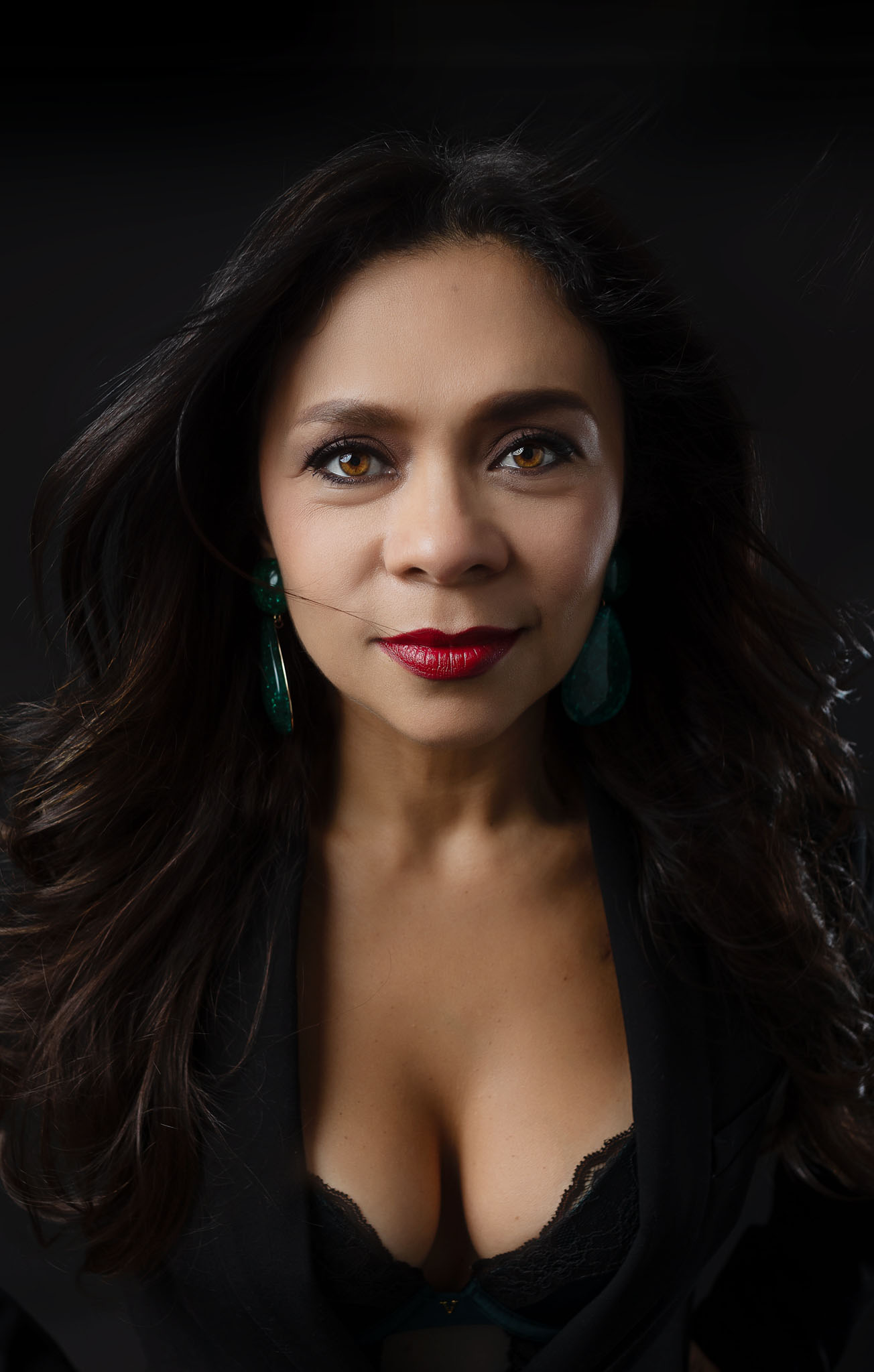 close up of a woman in a very professional way with black backdrop and red lipstick