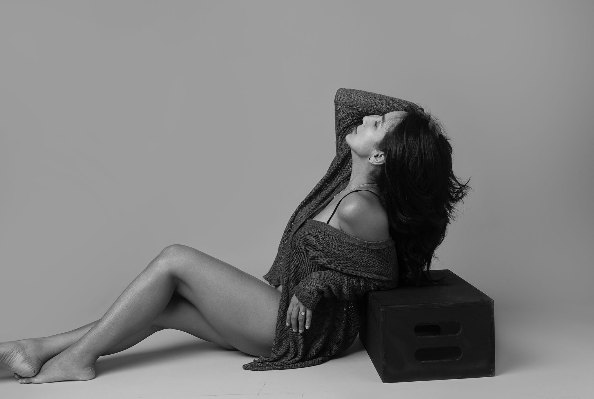 horizontal image of a woman in a boudoir session in black and white