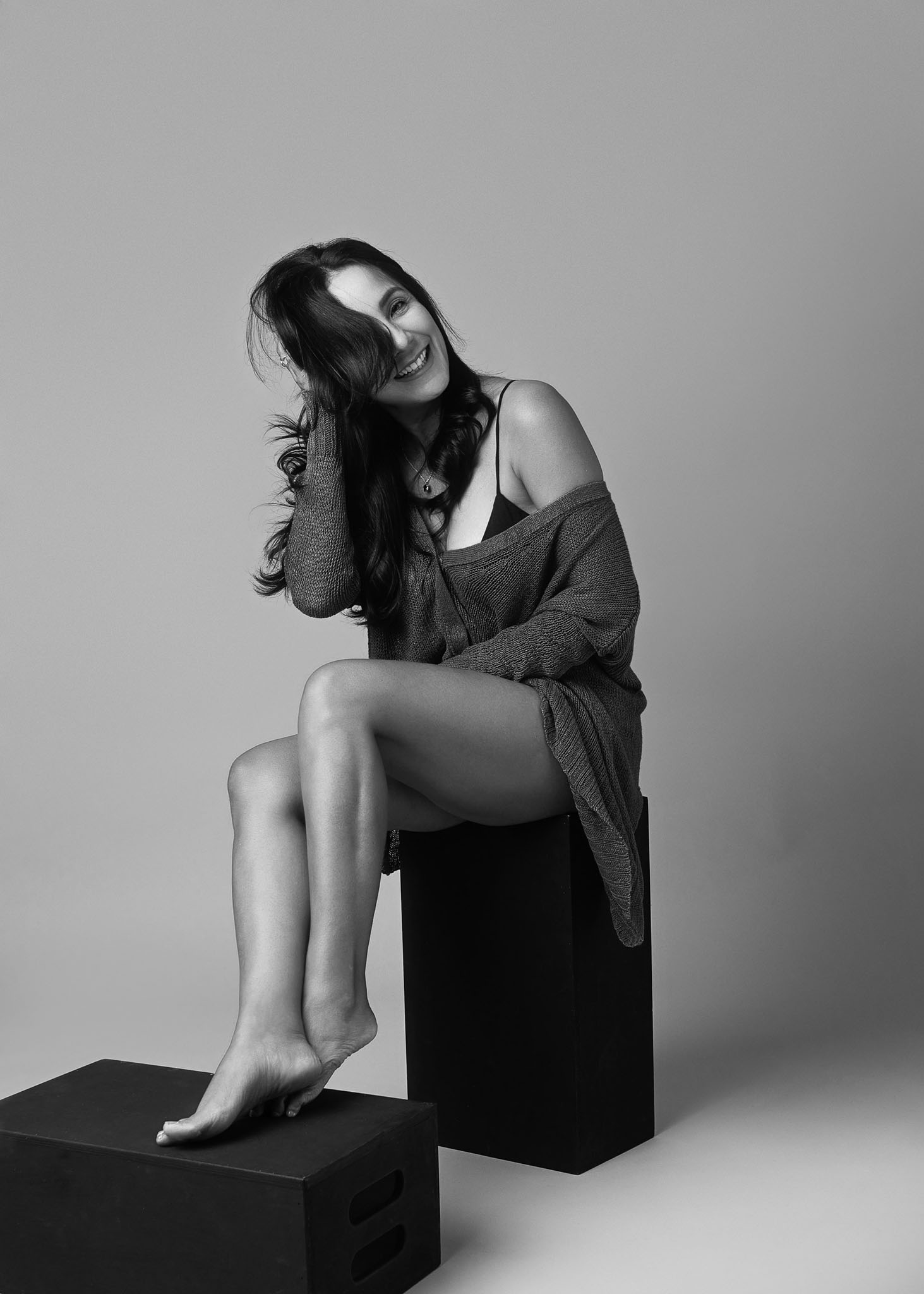 black and white portrait of a middle age woman laughing like she is enjoying her time in the studio