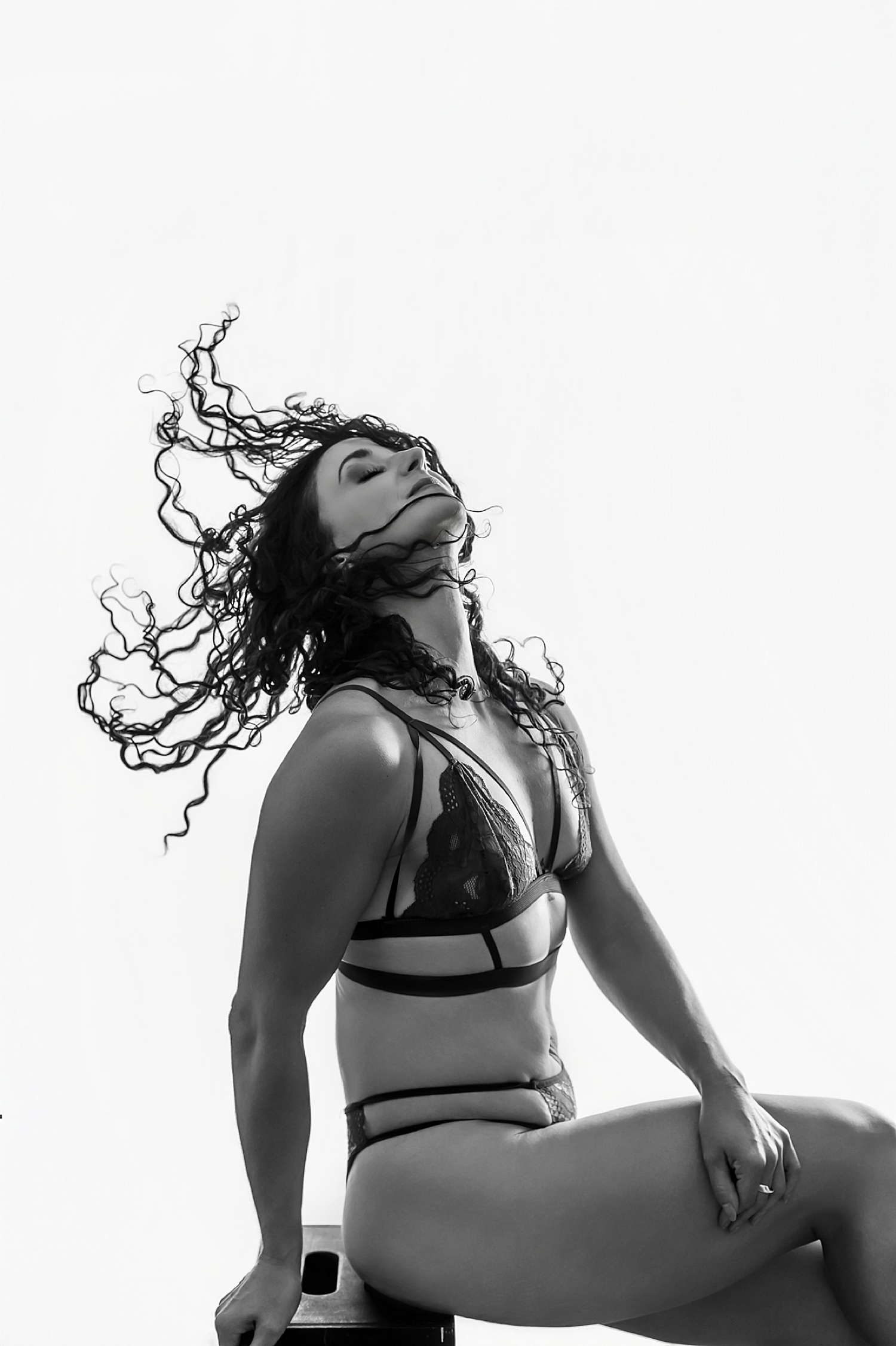 woman throws her hair through hair while wearing lingerie by Austin studio photographer